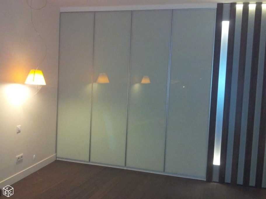 Porte coulissante en verre et mur avec lampe sur un fond clair.