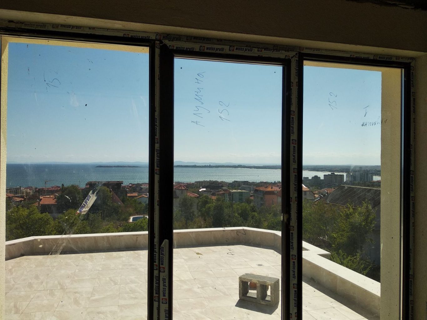 Vue panoramique sur un paysage côtier, à travers de grandes fenêtres.